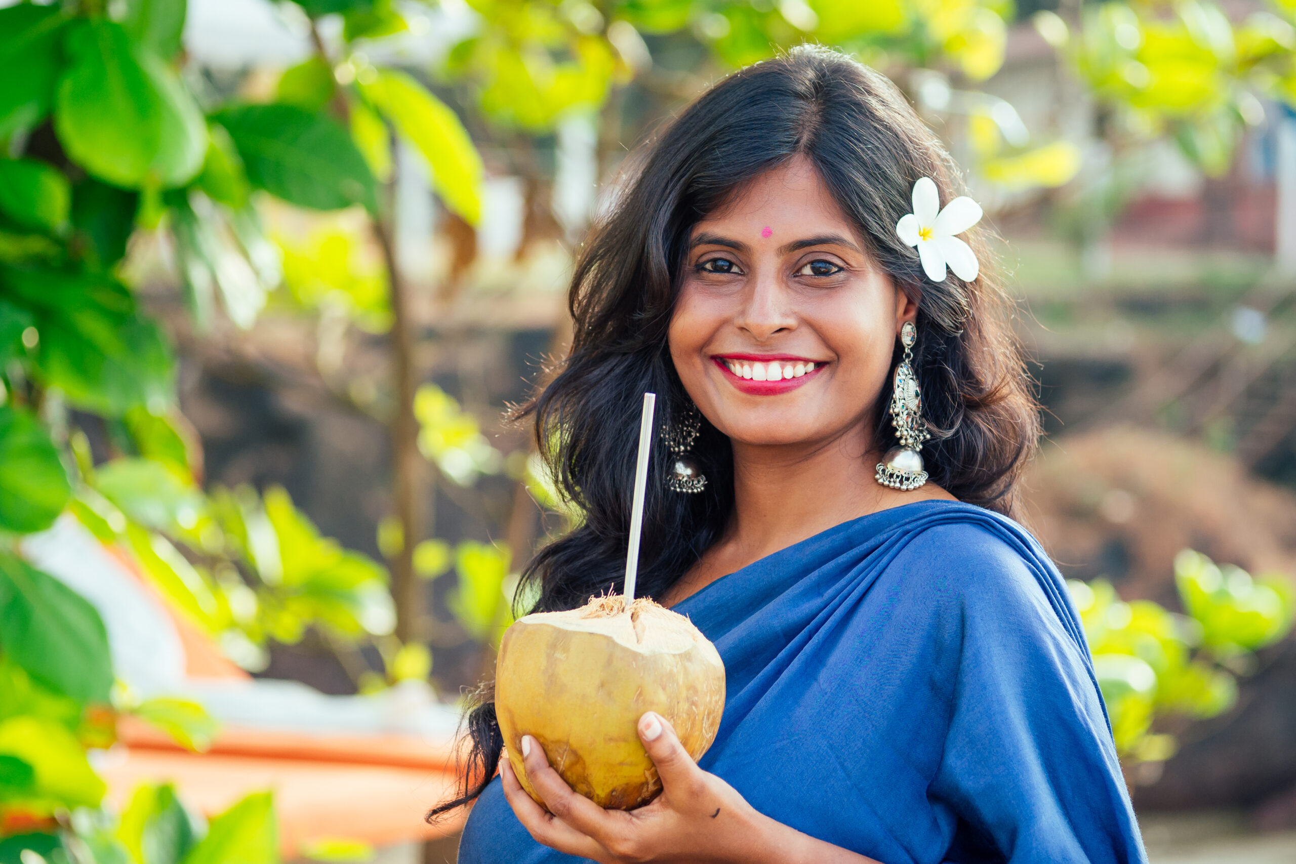 Happy indian woman coconut drink on the tropical beach.travel medical insurance concept.